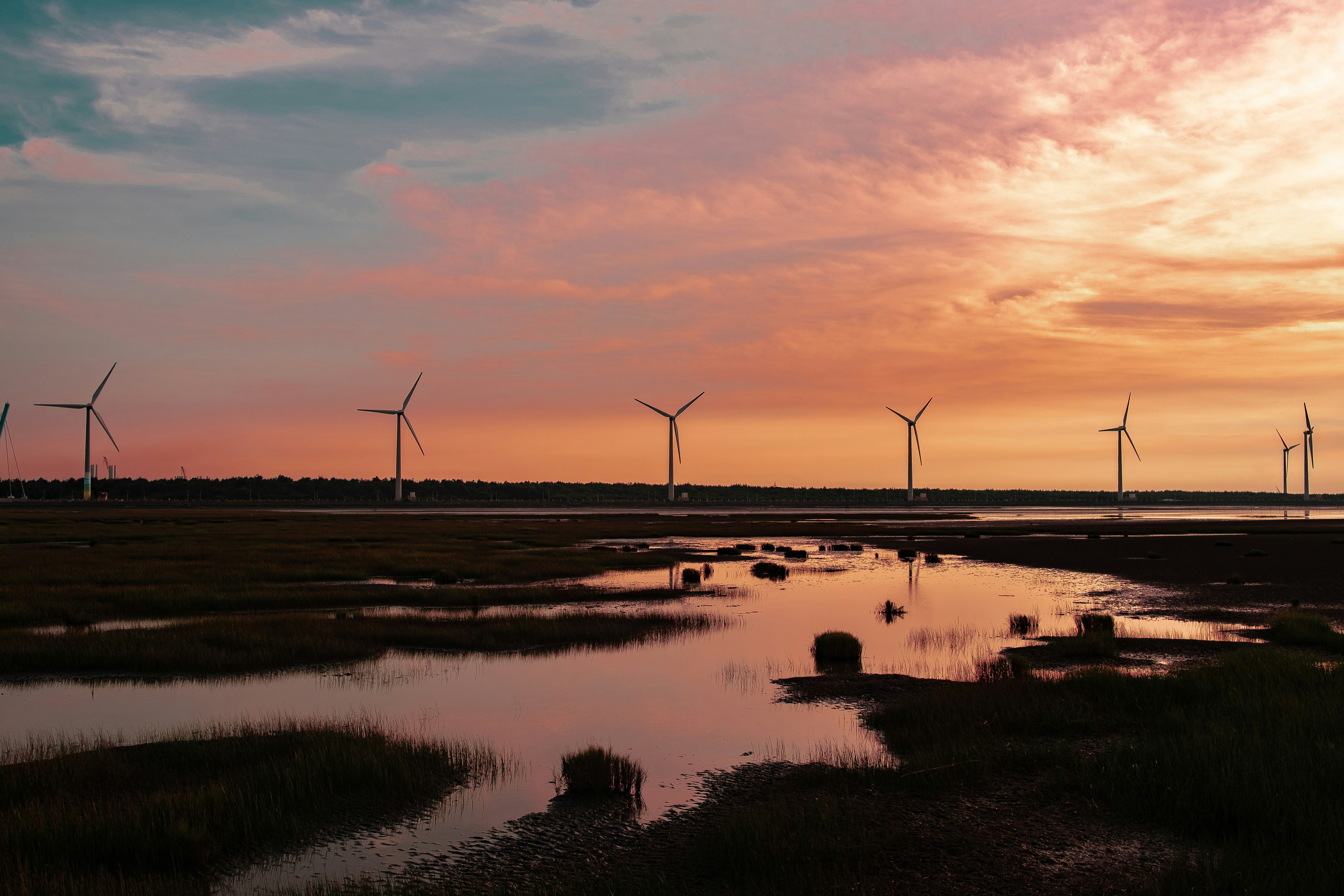 windmill near body of water during sunset